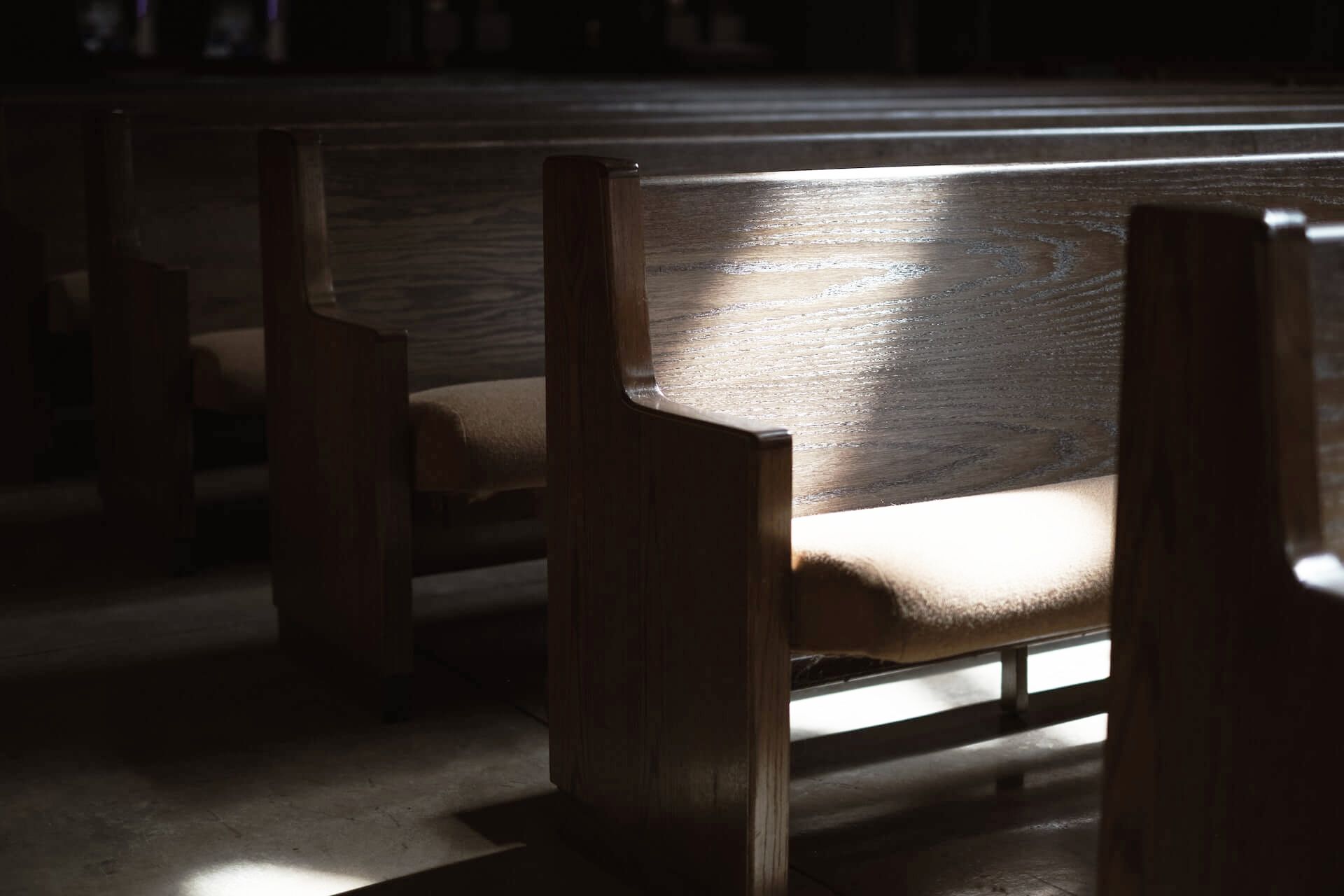 a highlighted empty church pew seat