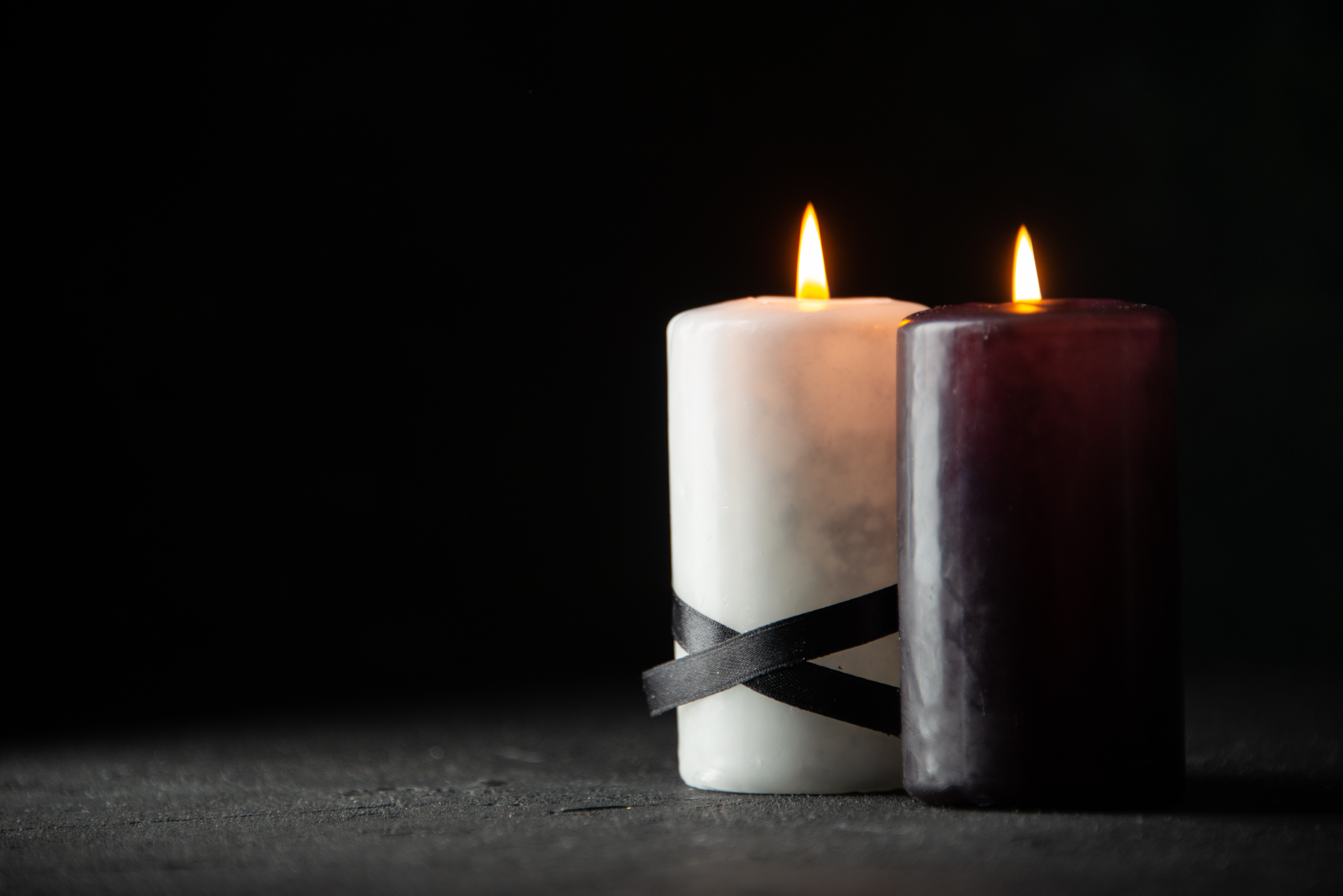 two lit candles, one black and one white